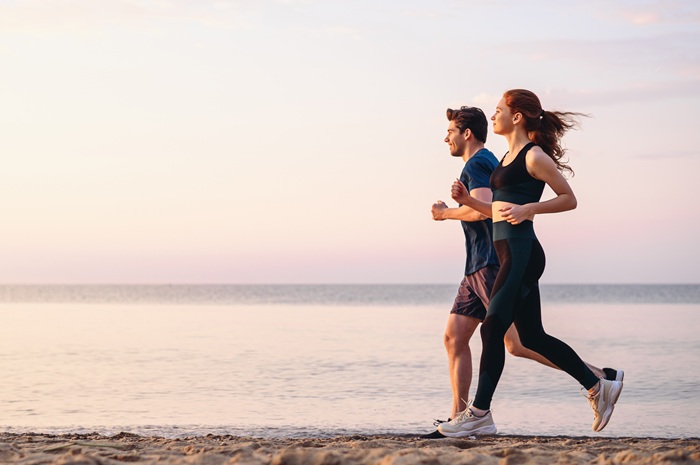 couple qui court sur la plage durant leur séjour de thalasso au Roz Marine